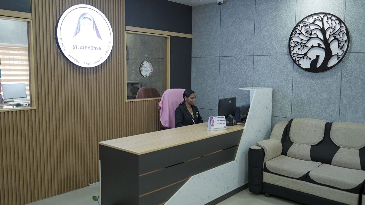 The school reception lobby with the illuminated school emblem on the wall behind the front desk