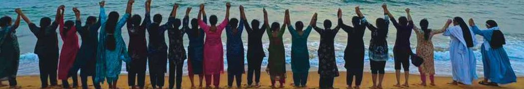 Staff members holding hands along the beach