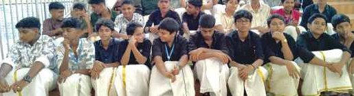 Students seated in auditorium on Onam