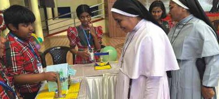 Sisters inspecting student science demonstration