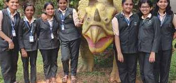 Students beside a dinosaur model