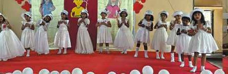 Girls in white dresses dancing on Children's Day