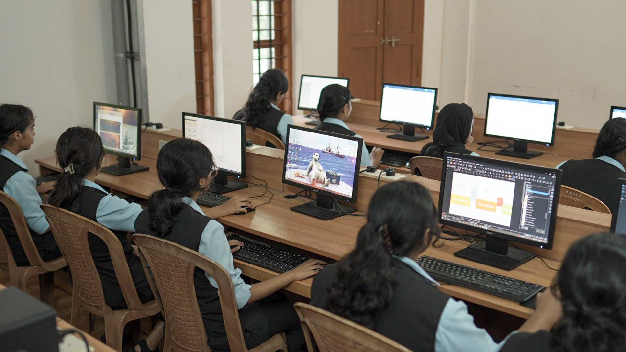 Female students working at desktop computer terminals in the school computer laboratory